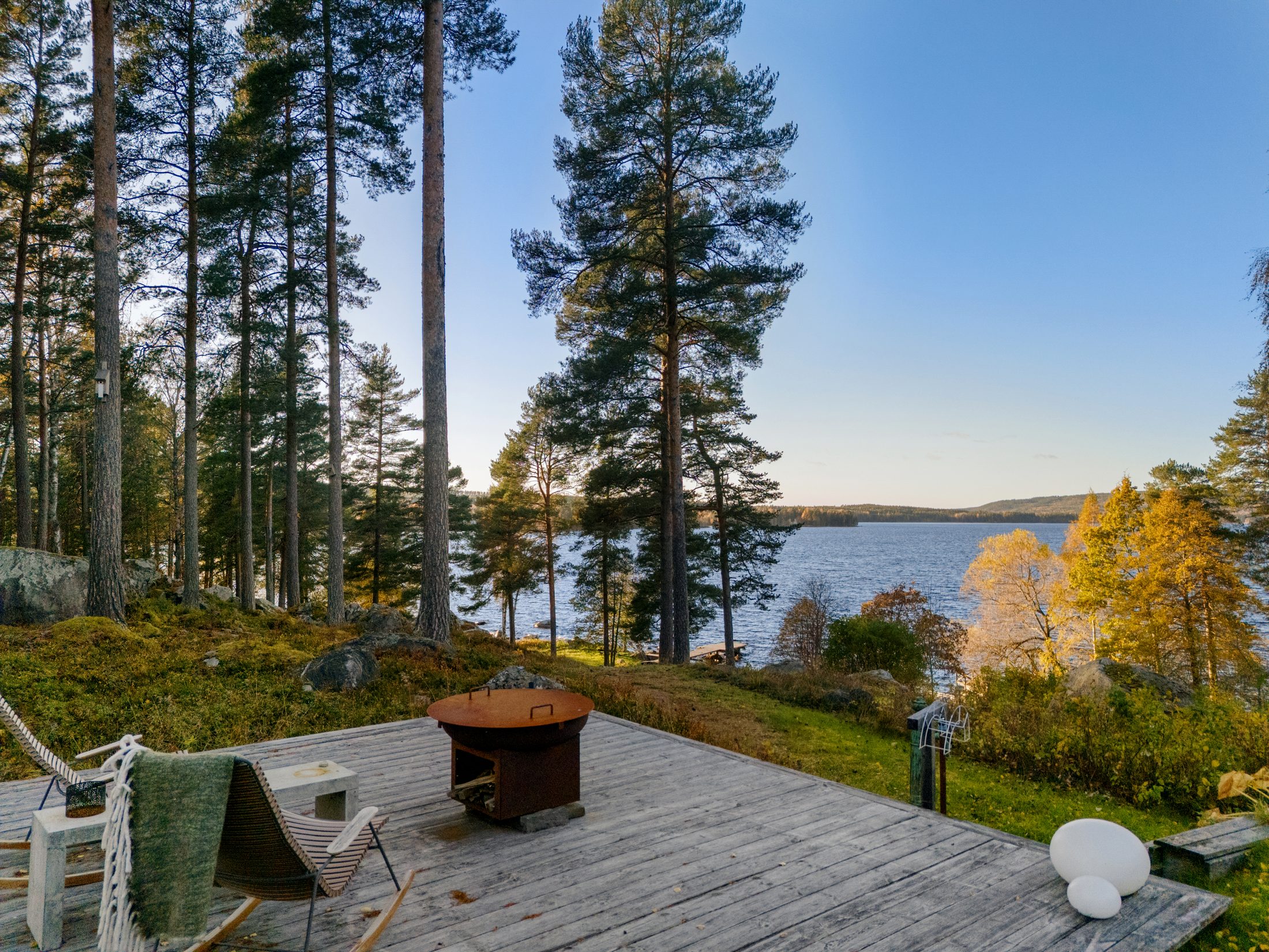 Trädäck med eldstad mot sjön