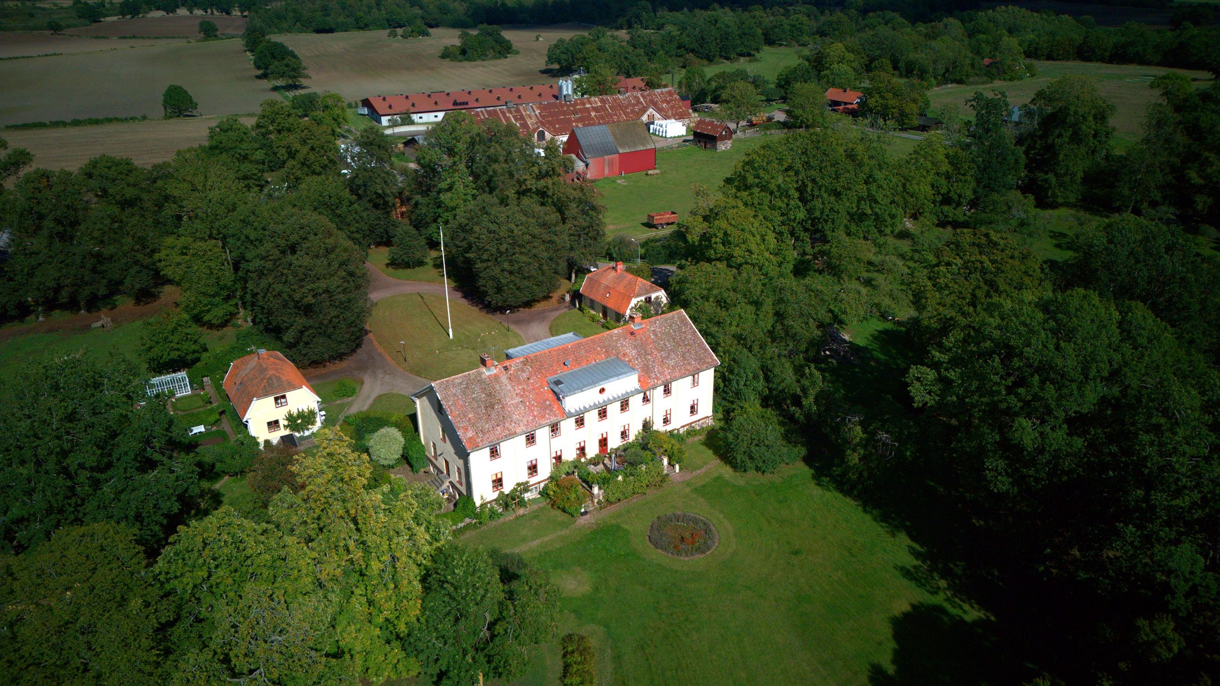 Herrgård med gårdsbyggnader och hagar ifrån ovan
